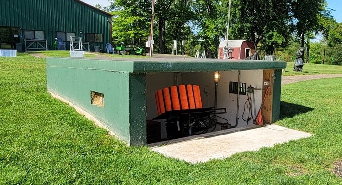 The trap house sits below the shooters’ line of sight; inside, the launcher must be maintained and adjusted to deliver regulation targets.